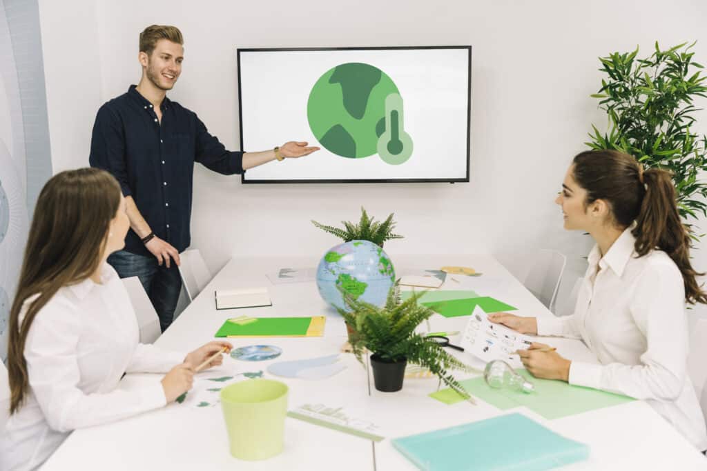 Profissionais discutem ESG e valor de mercado em sala de reunião com apresentação sobre sustentabilidade e mudanças climáticas.